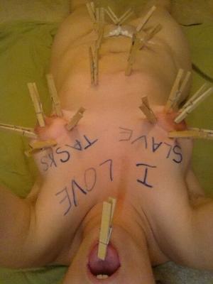 clothes pegs on naked slave