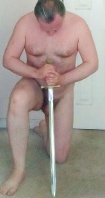 nude submissive male warrior kneeling with a sword