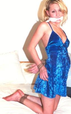 Woman in blue dress bound in bed