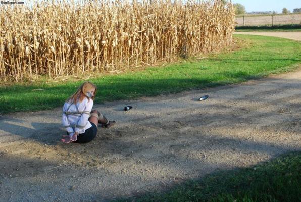 Gefesseltes und geknebeltes Mädchen auf der Waldstraße