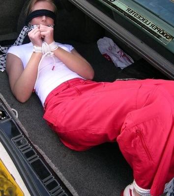 Woman with red trousers bound in car